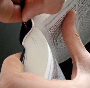 Lesebändchen mit der Klebefläche von innen an den Buchrücken legen.